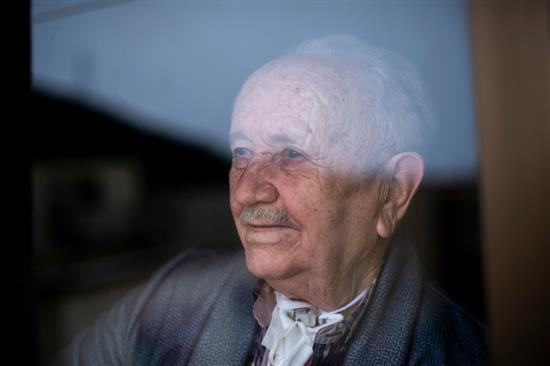 当地时间2021年3月2日，西班牙巴塞罗那，88岁的Jesus Blasco身患喉癌，透过公寓的窗户向外看。
